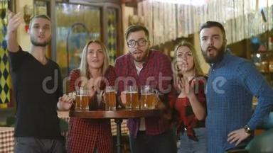 <strong>朋友圈</strong>-年轻人和女孩拿着啤酒杯，看着足球，在酒吧笑着
